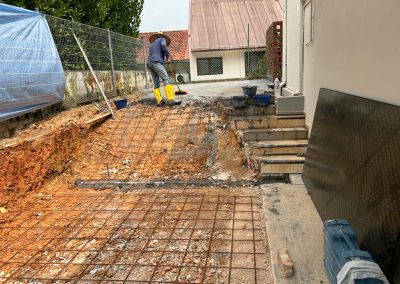 Skilled employee performing concrete flooring at a residential house, wearing safety gear