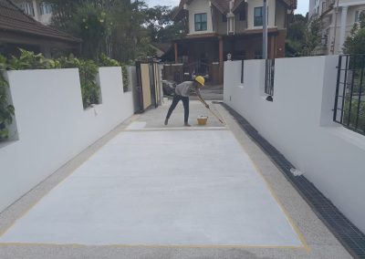 Worker coating driveway floor with protective layer