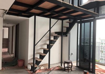 Indoor metal structure featuring wood stairs and awning installation