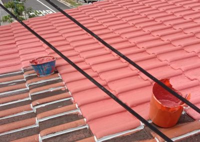 Old roof undergoing repairs, coating, and painting servicein progress