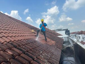 roof top view of clay shingle pressure washing by our employee