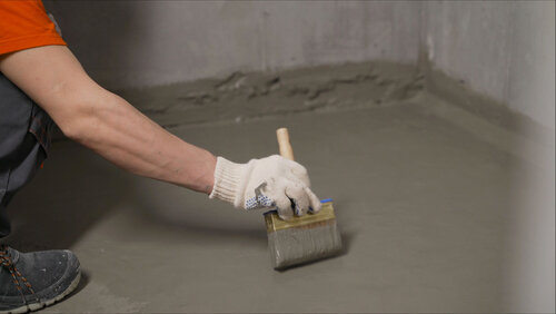 Employee applying sheet membrane waterproof coating on a roof with equipments